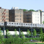 Alte Züge der New Yorker Subway auf der Hochbahn in der Bronx - im Hintergrund Wohnhäuser der Bronx