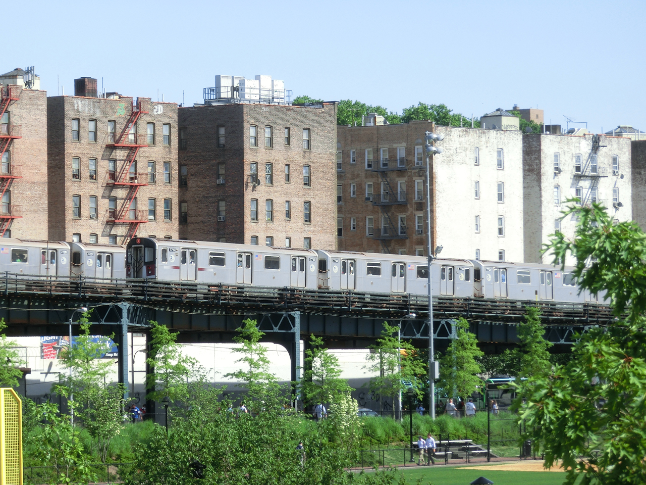 Alte Züge der New Yorker Subway auf der Hochbahn in der Bronx - im Hintergrund Wohnhäuser der Bronx