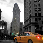 Flatiron Building mit gelbem NYC Taxi - in schwarz-weißer Umgebung