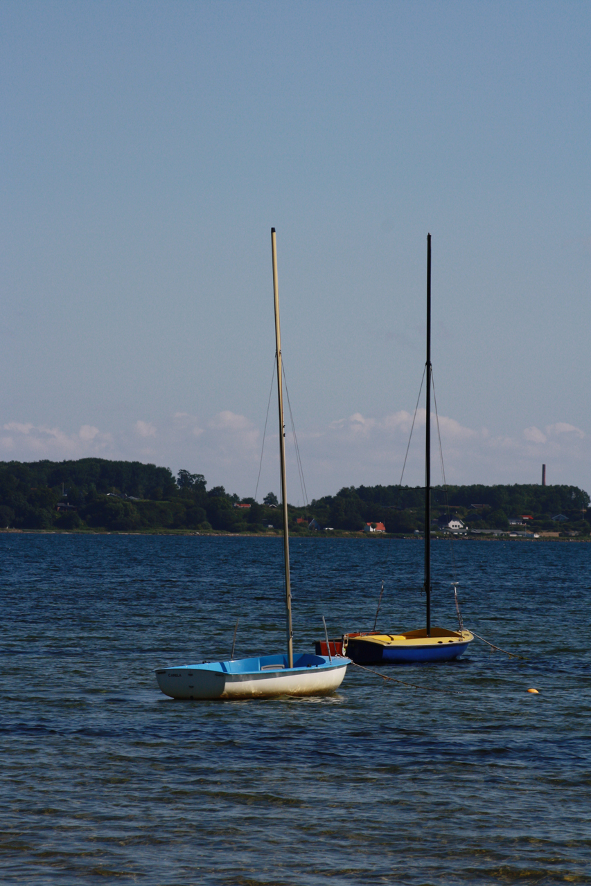 Kleine, malerische Boote im Wasser vor dem Naturstrand von Holnis