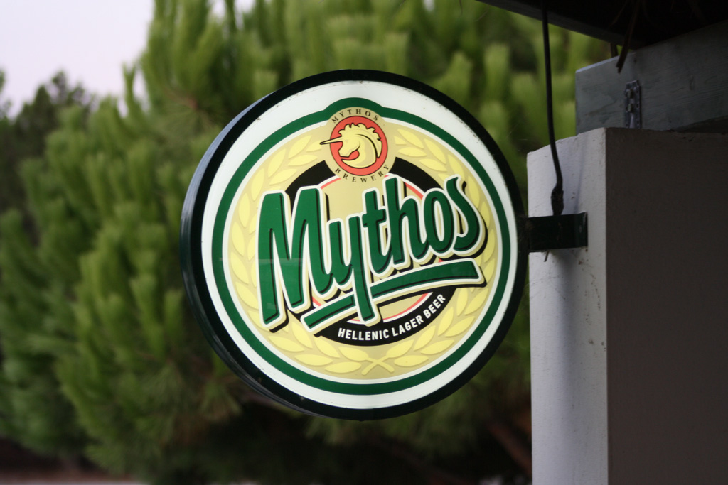 Schild einer Taverne mit dem Logo des grichischen Mythos-Bieres (Mythos Hellenic Lager Beer)