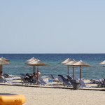 Sonnenschirme, Liegestühle und das blaue Meer am Strand von Keramoti