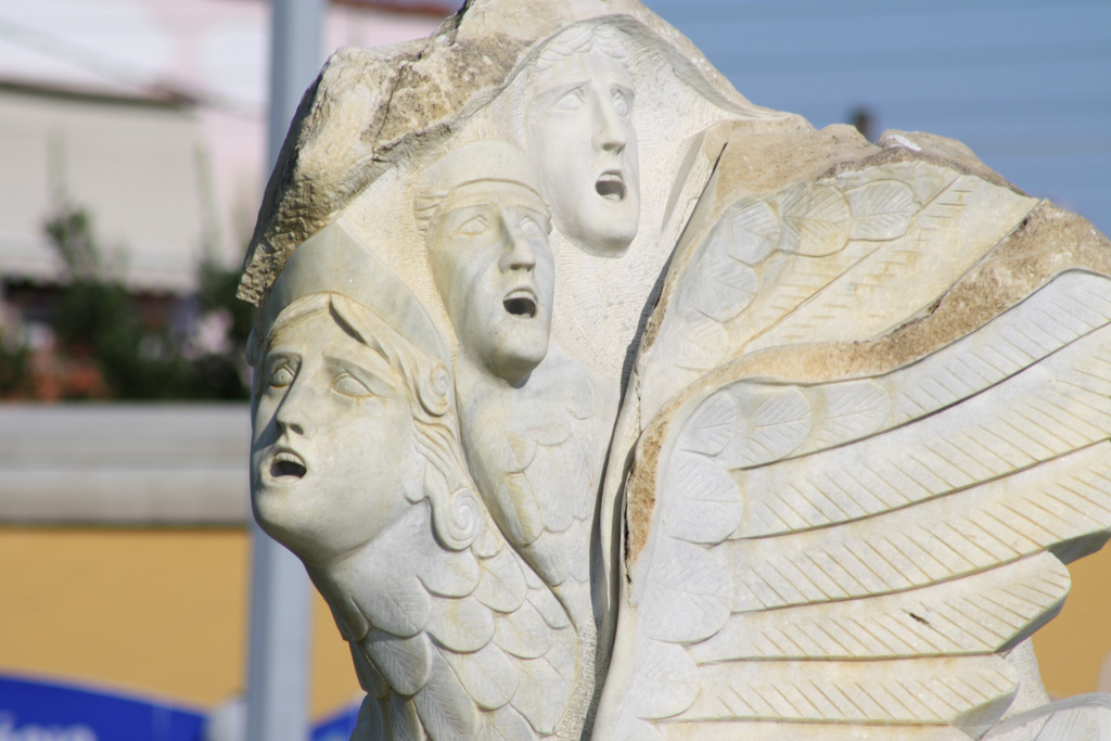 Skulptur an der Hafenpromenade mit drei schreinden Gesichtern